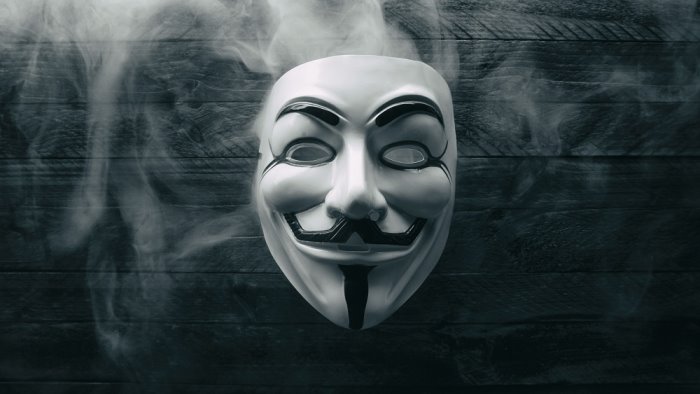 una pistola e la rapina in una farmacia con la maschera di anonymous