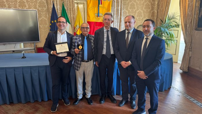 manfredi consegna una targa a domenico formato interprete di capuozzo